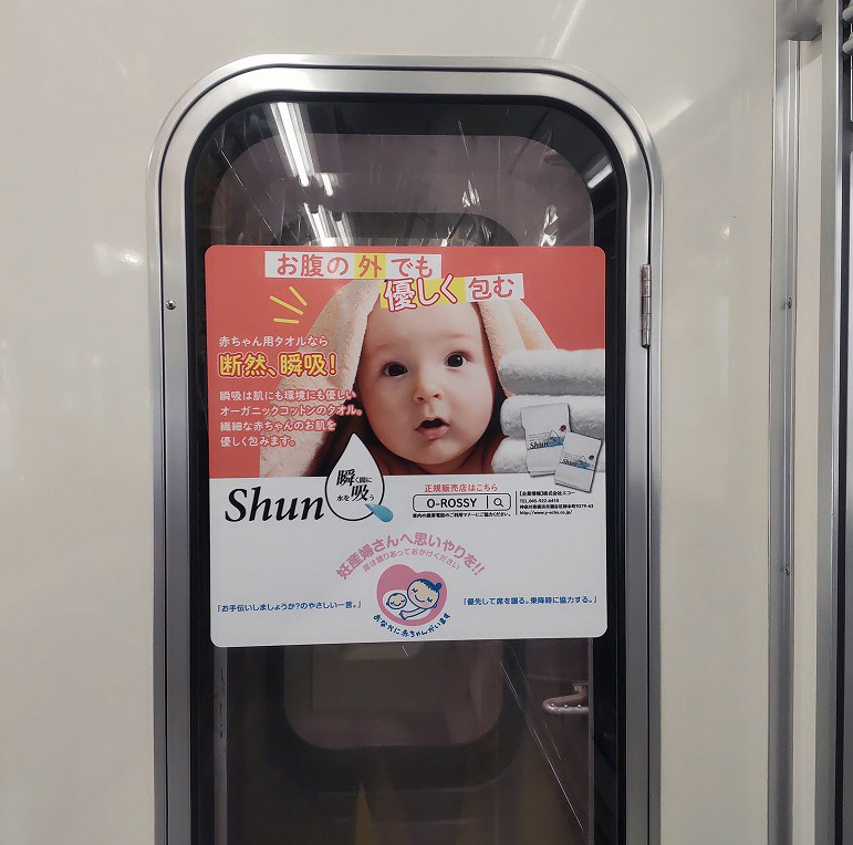 マタニティマークとのタイアップで、都営三田線の優先席エリアにて期間一年の広告を開始しました。